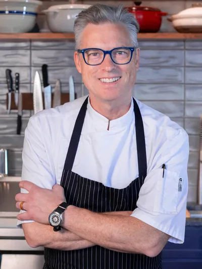 Chef Patrick O'Halloran of The Deliciouser, arms crossed in his kitchen